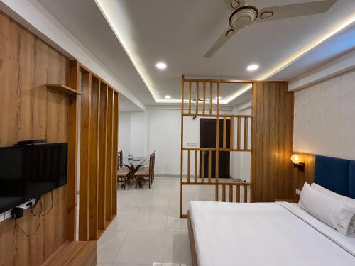 1 dormitorio con 1 cama, TV y mesa en Hotel Shri Radha Nikunj - Opposite Prem Mandir, en Vrindāvan