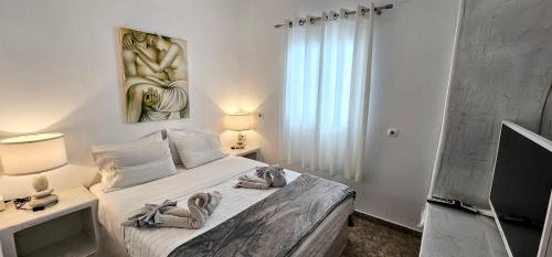 a bedroom with a bed with two towels on it at Pleasure Black Beach Perissa Santorini in Perissa