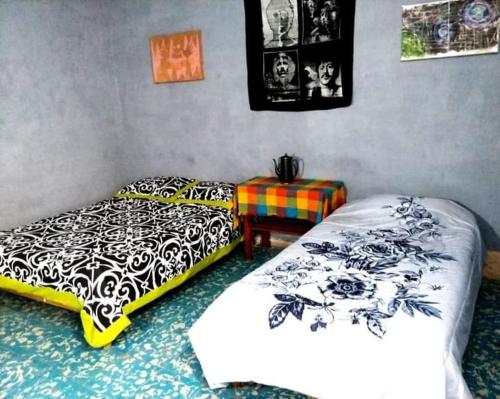 a bedroom with two beds and a table in it at Posada Hortencia in La Huerta