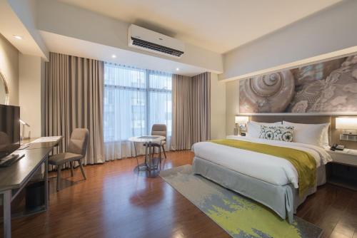 a hotel room with a large bed and a desk at Citadines Millennium Ortigas Manila in Manila