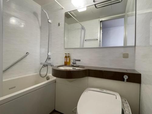 y baño con aseo, lavabo y espejo. en Hotel Alpha-One Gotemba Inter, en Gotemba