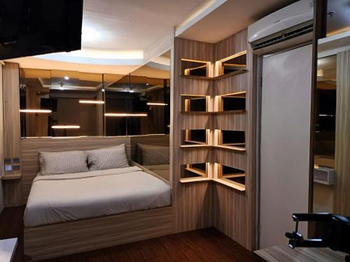 a small bedroom with a bed and shelves at Grandboutique-Inn in Jakarta