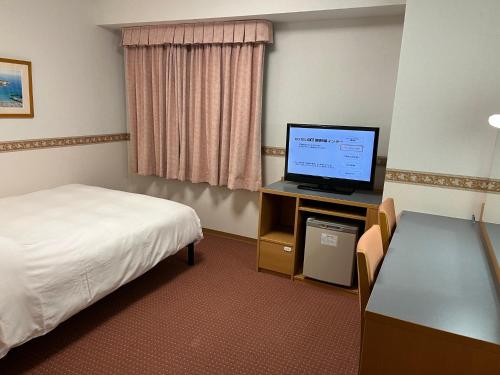 御殿場市にあるホテルアルファーワン御殿場インターのベッド1台、薄型テレビが備わるホテルルームです。