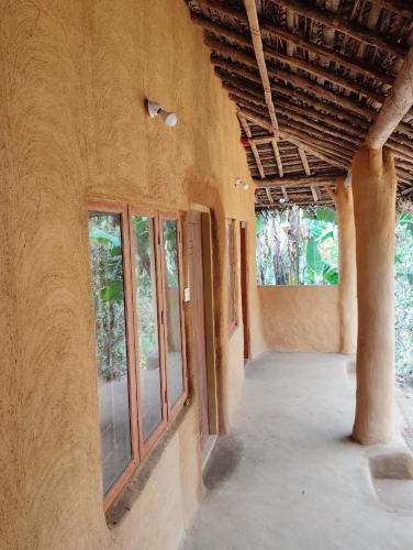 an empty hallway of a house with windows at Cosmic Mud House Kanthalloor in Kanthalloor