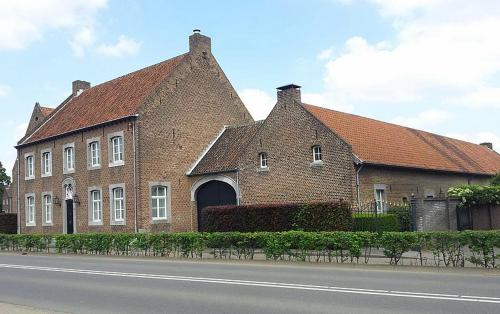 a large brick building with a red roof at Hoeve de Hoge Swaen in Maastricht