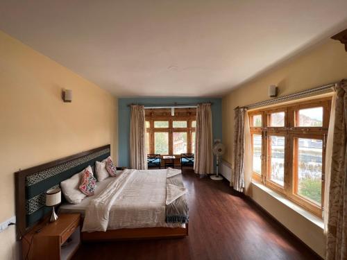 1 dormitorio con cama y ventana grande en Hotel New Glacier View, en Leh