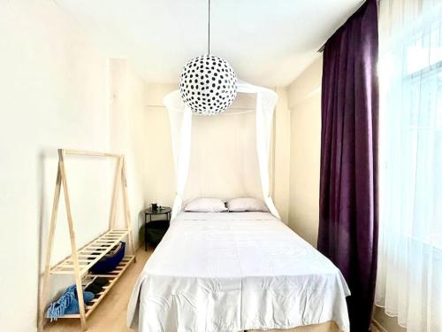 a bedroom with a white bed and a pendant light at Cozy House in İzmir