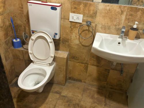 een badkamer met een toilet en een wastafel bij Rajhans Belizia JSM in Surat