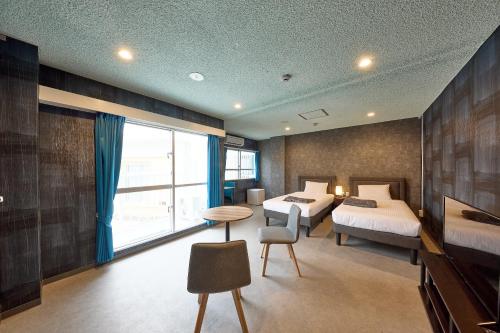 1 Schlafzimmer mit 2 Betten und einem großen Fenster in der Unterkunft Hotel CABANA カバナ 宮古島 in Miyako-jima