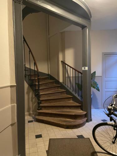 a hallway with a staircase in a house with a bike at Appart cosy belle vue CENTRE Vitré in Vitré