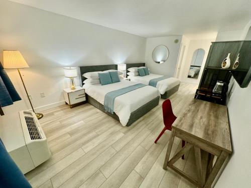 a hotel room with two beds and a desk at Pool - WiFi - Parking - Best Location ! in Kissimmee