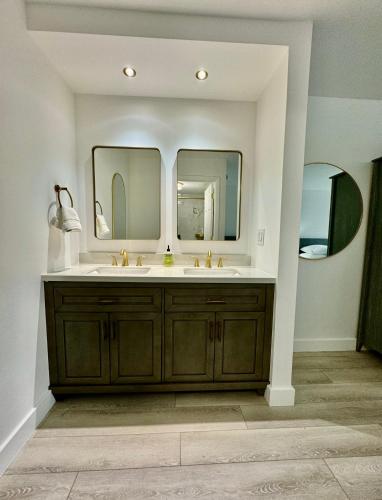a bathroom with a sink and two mirrors at Pool - WiFi - Parking - Best Location ! in Kissimmee