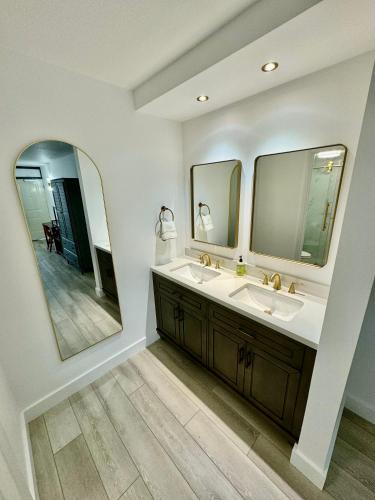 a bathroom with a sink and two mirrors at Pool - WiFi - Parking - Best Location ! in Kissimmee