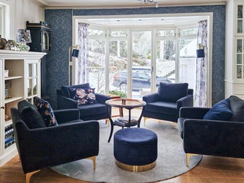 - un salon avec des chaises bleues et une table dans l'établissement Holiday home TJODALYNG, 