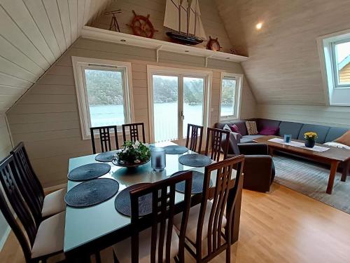 a dining room and living room with a table and chairs at Seaside Fisherman s Haven-By Traum in Steinsbø