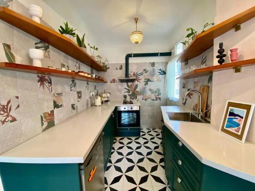 a kitchen with green cabinets and a sink and a counter at Buena Vista Athens in Athens