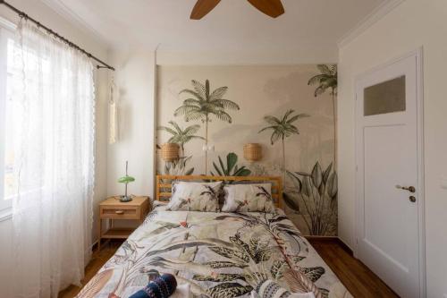 a bedroom with a bed with palm trees on the wall at Buena Vista Athens in Athens