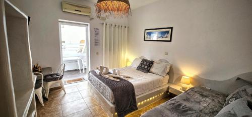 a bedroom with a bed with two stuffed animals on it at Pleasure Black Beach Perissa Santorini in Perissa