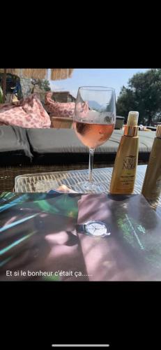 a glass of wine sitting on top of a table at Residence Paradisu Ajaccio in Appietto