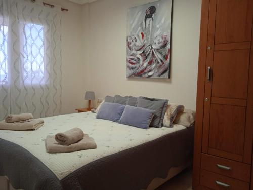 1 dormitorio con 1 cama con toallas en Vista al Mar with Parking Space, en La Mata