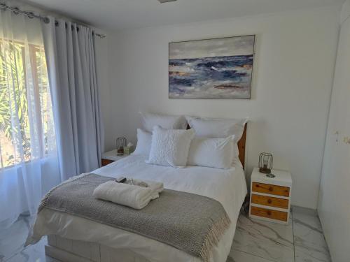 um quarto com uma cama com lençóis brancos e uma janela em A&F Cottage with pool n braai em Sandton
