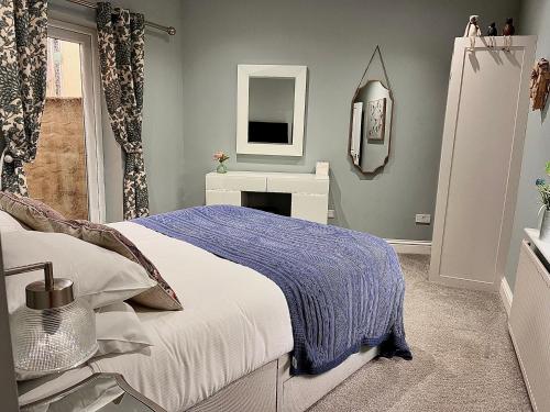 a bedroom with a bed and a mirror at Castle Cottage in Harrogate