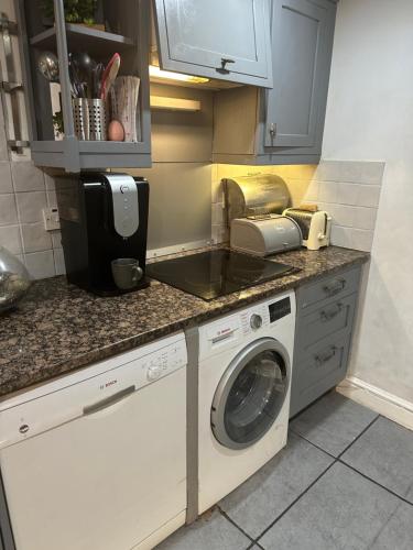 a kitchen with a washing machine and a sink at My Sky LDN Secret Garden in London