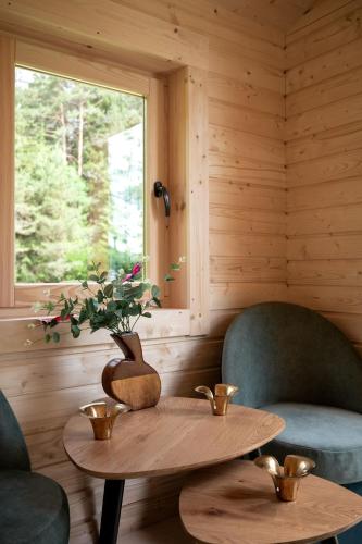a room with two chairs and a table and a window at Miškas Arjola in Kaltanėnai