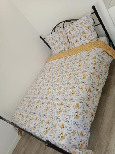 uma cama com uma estrutura de cama com flores em Joli em Clichy