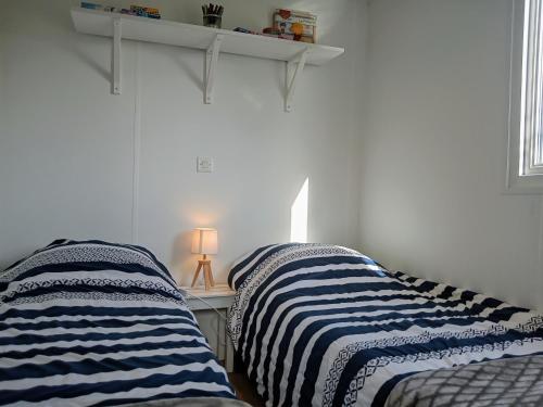 two beds sitting next to each other in a bedroom at LE RHUYS, mobil home cosy proche des plages in Sarzeau