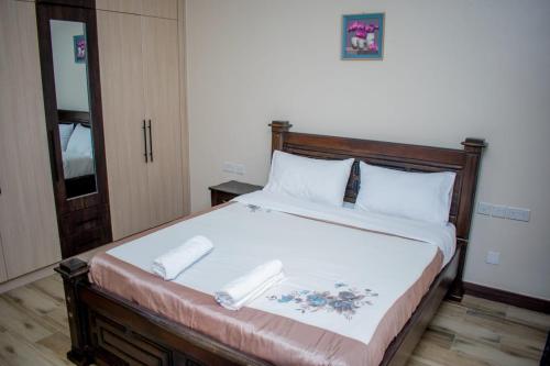 a bedroom with a large bed with white sheets and pillows at Lalucia in Nairobi