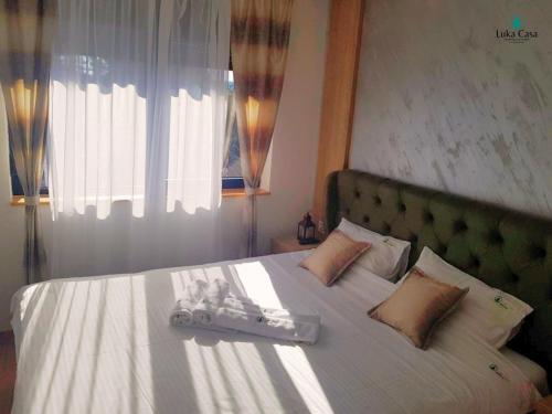 - une chambre avec un grand lit et un couvre-lit blanc dans l'établissement Apartman Luka Casa, à Zlatibor