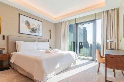 a bedroom with a bed and a desk and a window at 2Bed Dubai Address Opera Residence sea view - Downtown near Burj Khalifa- 5 min walk Dubai mall in Dubai