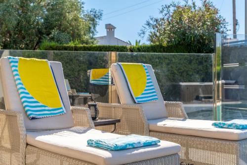 three wicker chairs with yellow and blue cushions at Villa Paradise in El Campello
