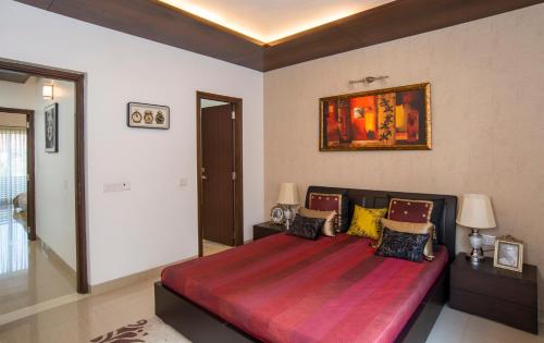 a bedroom with a large bed with a red blanket at WOODS - Mangalyam Meadows in Valsad