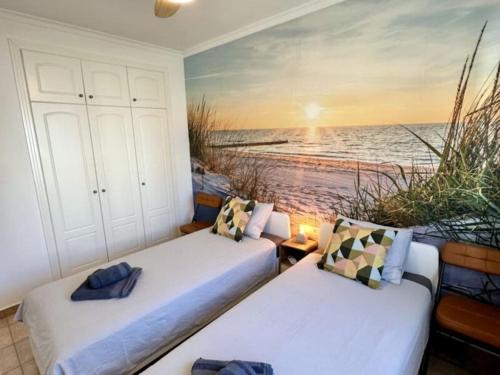 two beds in a room with a view of the ocean at Tranquil two bedroom house in Beniarbeig in Beniarbeig