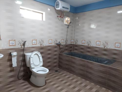 łazienka z toaletą i wanną w obiekcie Restful River Villas w mieście Phong Nha