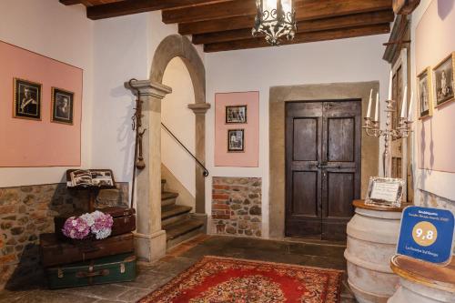 a hallway with a door and a staircase with a rug at LA FINESTRA SUL TRAMONTO Dimora Storica in Laterina