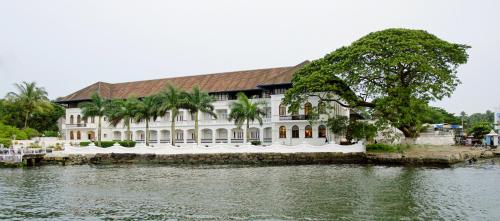a large white building next to a body of water at Brunton Boatyard - CGH Earth in Cochin