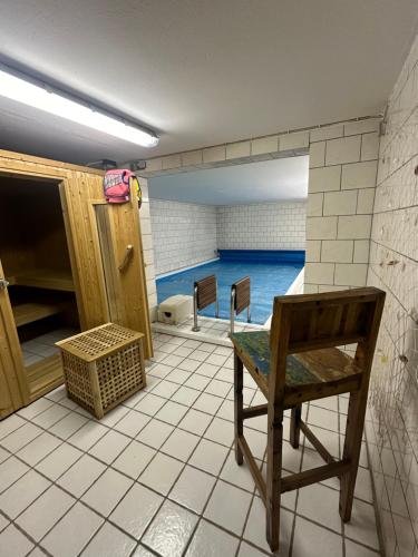 a empty room with a chair and a swimming pool at 2 Zimmer Wohnung Pool u. Sauna Zugang möglich 