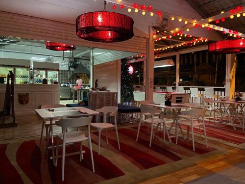 um restaurante com mesas, cadeiras e luzes vermelhas em SLAV Naithon Boutique Hotel and Restaurant em Phuket