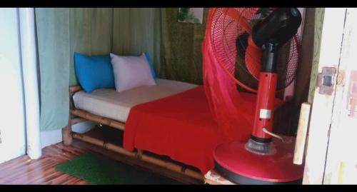 Bacungan的住宿－A&Z Nagtabon Lodge，小房间设有床铺和红色风扇