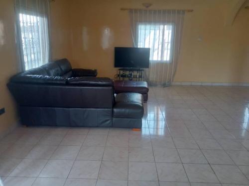 sala de estar con sofá y TV en Costal Road hideout!, en Ghana Town