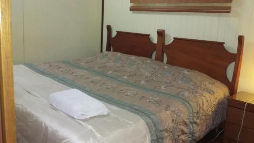 a bed with a white pillow on top of it at Boutique Hotel Casa Orquídeas in San José