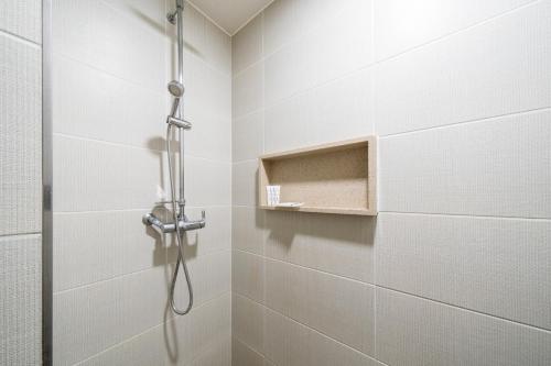 La salle de bains est pourvue d'une douche et d'une porte en verre. dans l'établissement I-check Hyunjin Hotel, à Donghae