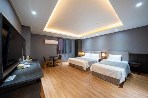 Habitación de hotel con 2 camas y TV de pantalla plana. en I-check Hyunjin Hotel en Donghae