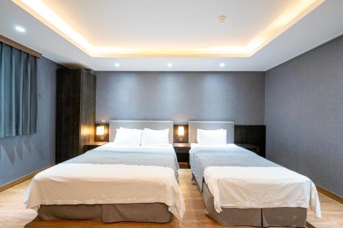 two beds in a hotel room with two bedsvisor at I-check Hyunjin Hotel in Donghae