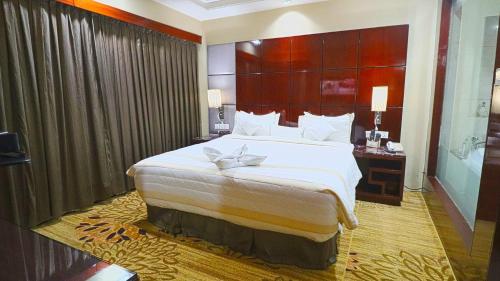SkyCity Hotel Gurgaon في جورجاون: غرفة نوم بسرير كبير مع اللوح الأمامي كبير