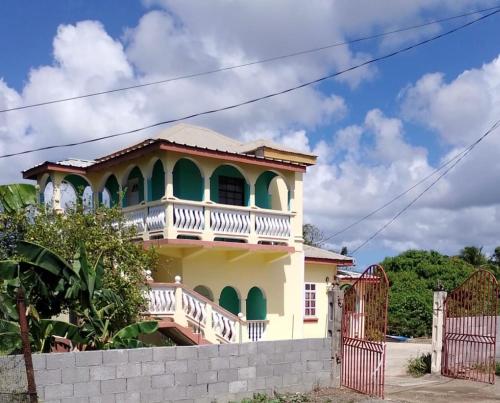 a house with a balcony on top of it at Grand Vue Apartment Vieux Fort in Vieux Fort
