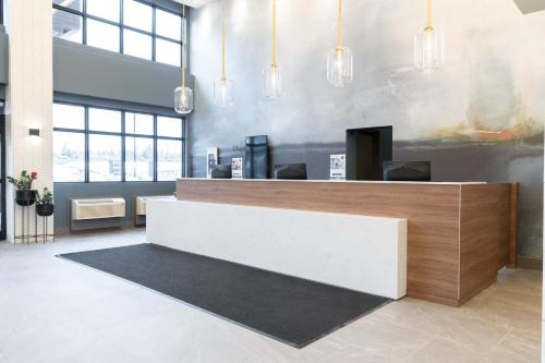 a lobby with a reception desk in a building at Sandman Signature Dartmouth Hotel & Suites in Halifax